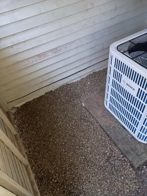 Fresh gravel leveled around a Bosch heat pump after trench backfill