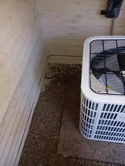 Gravel bed restored beside an outdoor AC unit after the supply line was repaired
