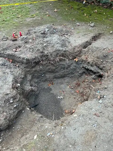Pea gravel bedding under a black water line in a pit