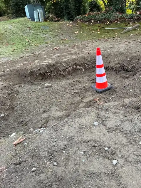 Safety cone on a backfilled and raked excavation area