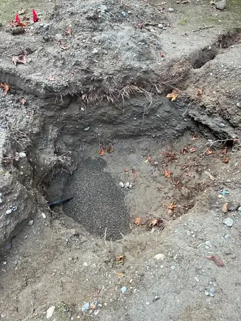 Excavation pit with clean pea gravel bedding placed under a new black water line