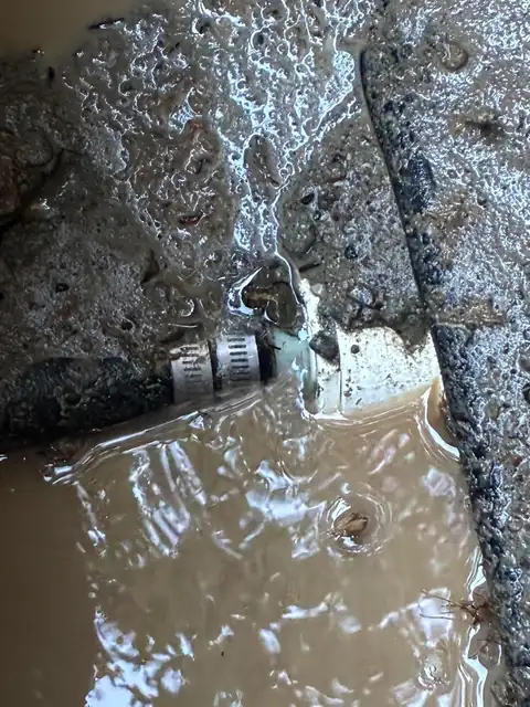 Leaking fitting and clamp submerged in muddy water